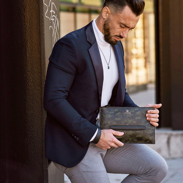 Green camouflage leather hand bag in use, held by man in blazer and grey pants