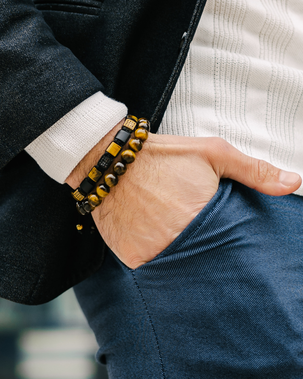 Wrist bracelet with tiger eye bead row, black accents, and braided cord clasp