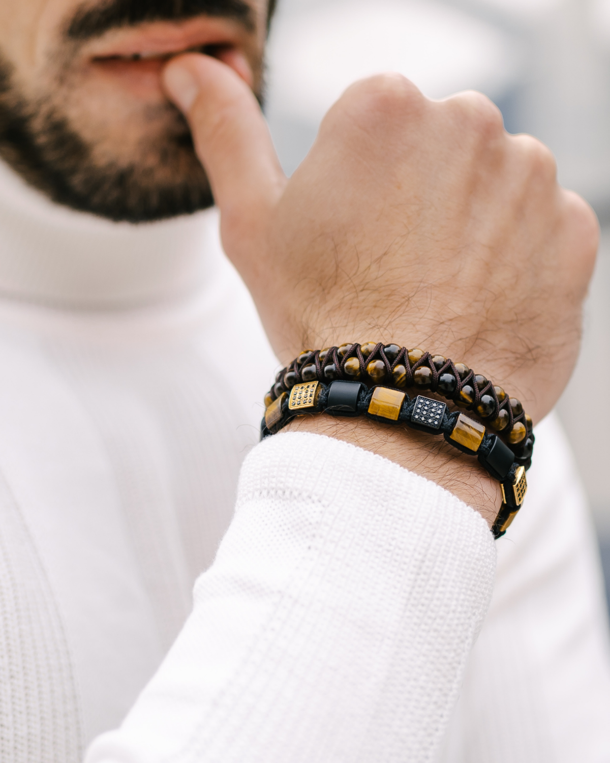 Wrist-worn bracelet: black cord with tiger eye and black onyx beads, gold caps