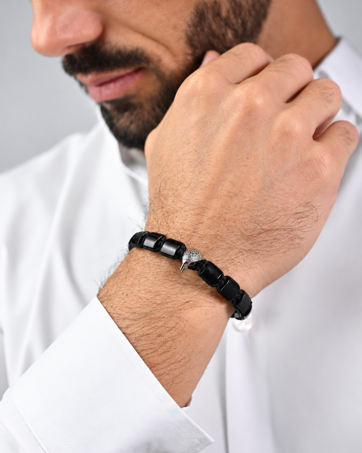 Black beaded bracelet on wrist with silver-toned connector beads