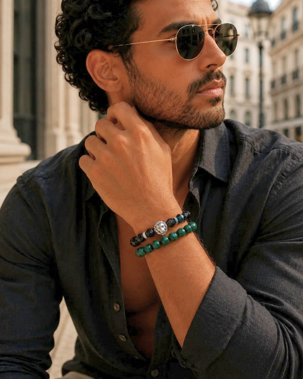 Two beaded bracelets on wrist: black beads and green gemstone-style beads