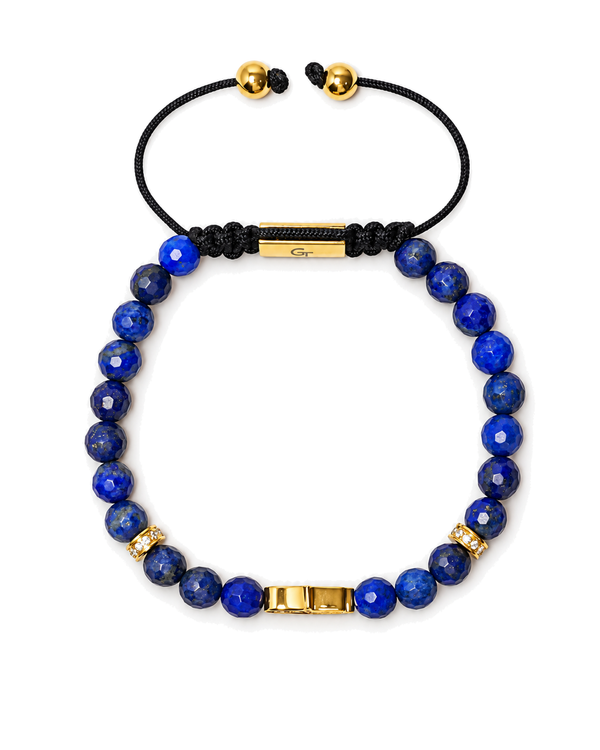 Blue lapis bead bracelet with gold bar clasp, black cord ends, gold round beads.