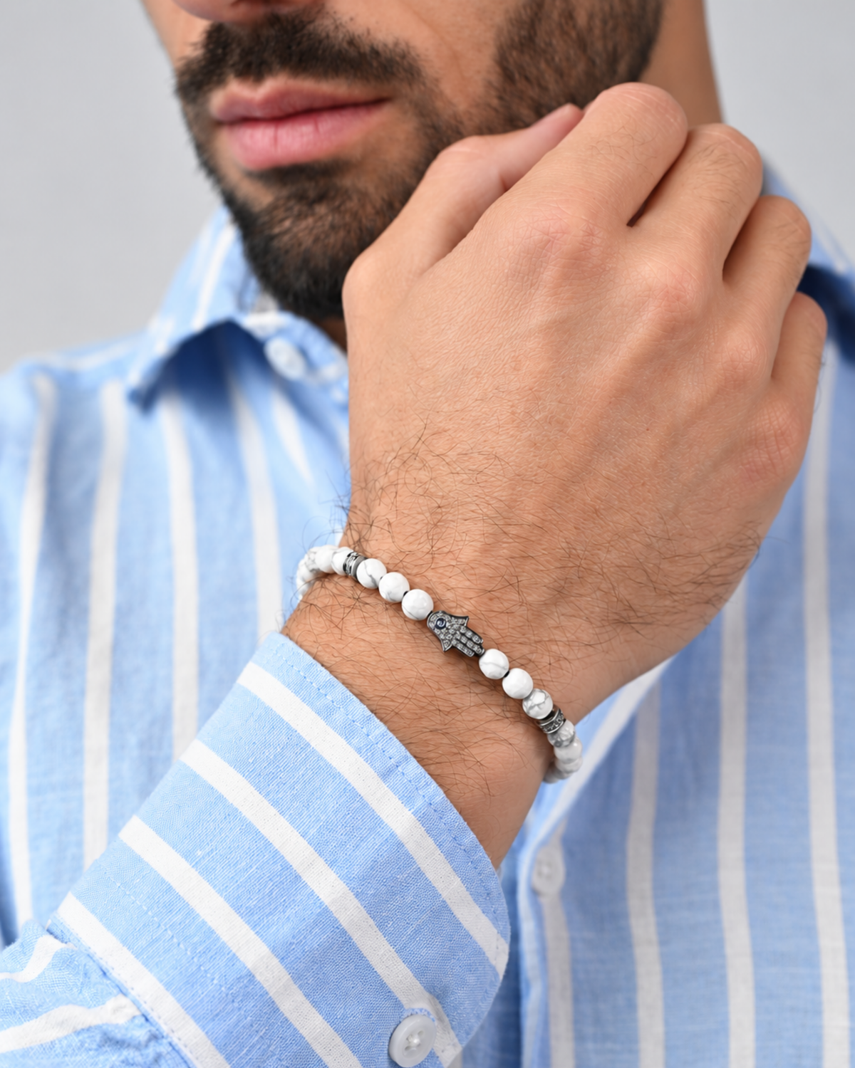 Howlite bead bracelet with hamsa hand charm on a man’s wrist