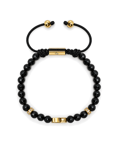 Black beaded bracelet with gold clasp beads and black cord tie ends.