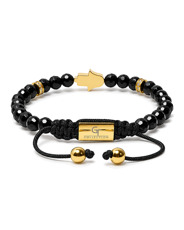 Black beaded bracelet with gold Hamsa centerpiece and 'G Collection' clasp tag.