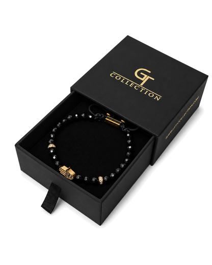Black beaded bracelet with gold Hamsa charm in a black gift box with pouch.