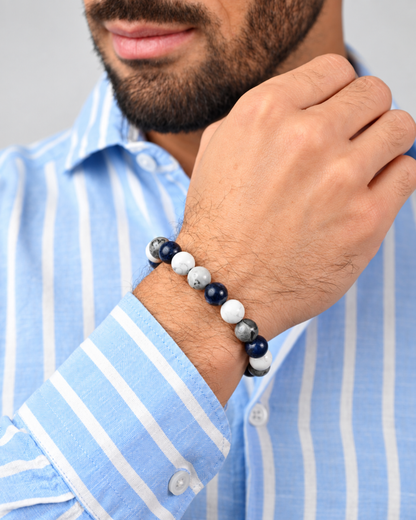 Beaded bracelet worn on a man’s wrist with blue, white, and gray round stones