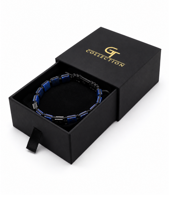 Blue and black bead bracelet with flat lapis-like beads, shown in a black gift box