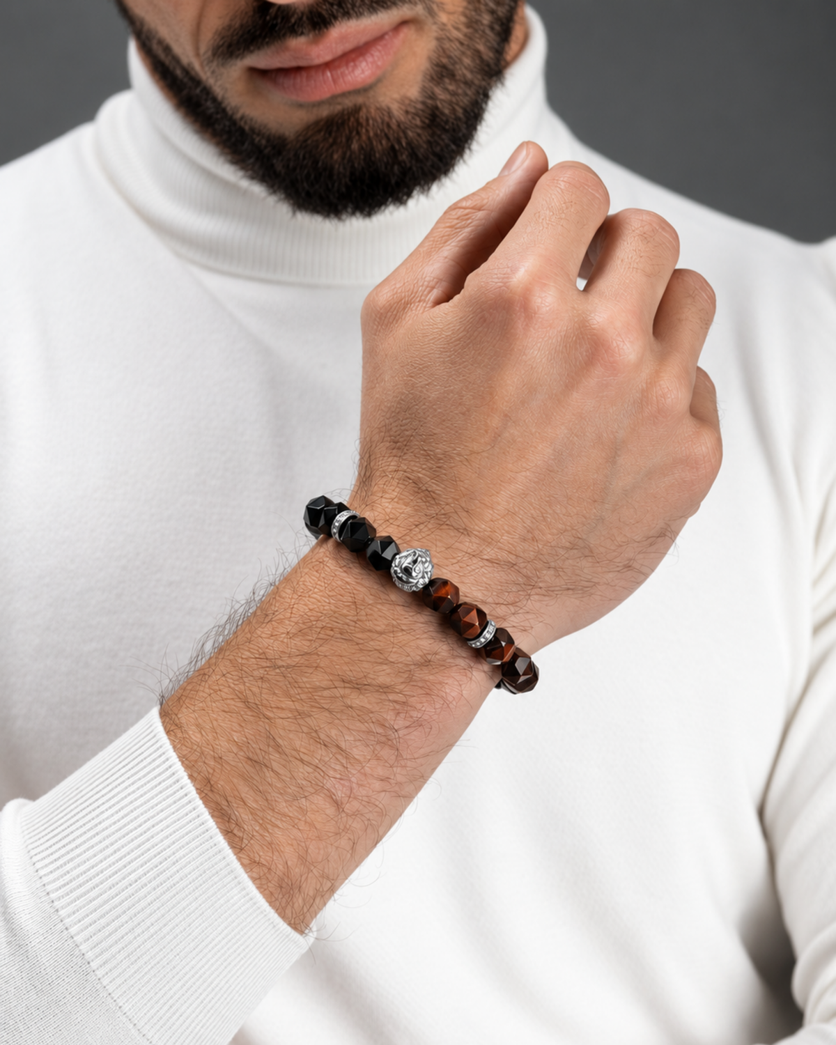 Wrist-worn beaded bracelet with lion charm, black beads and orange-brown stone beads.