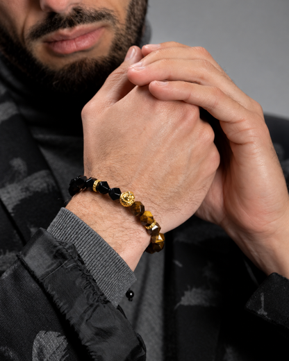 Worn lion charm bracelet on wrist with black beads and tiger-eye gold accents