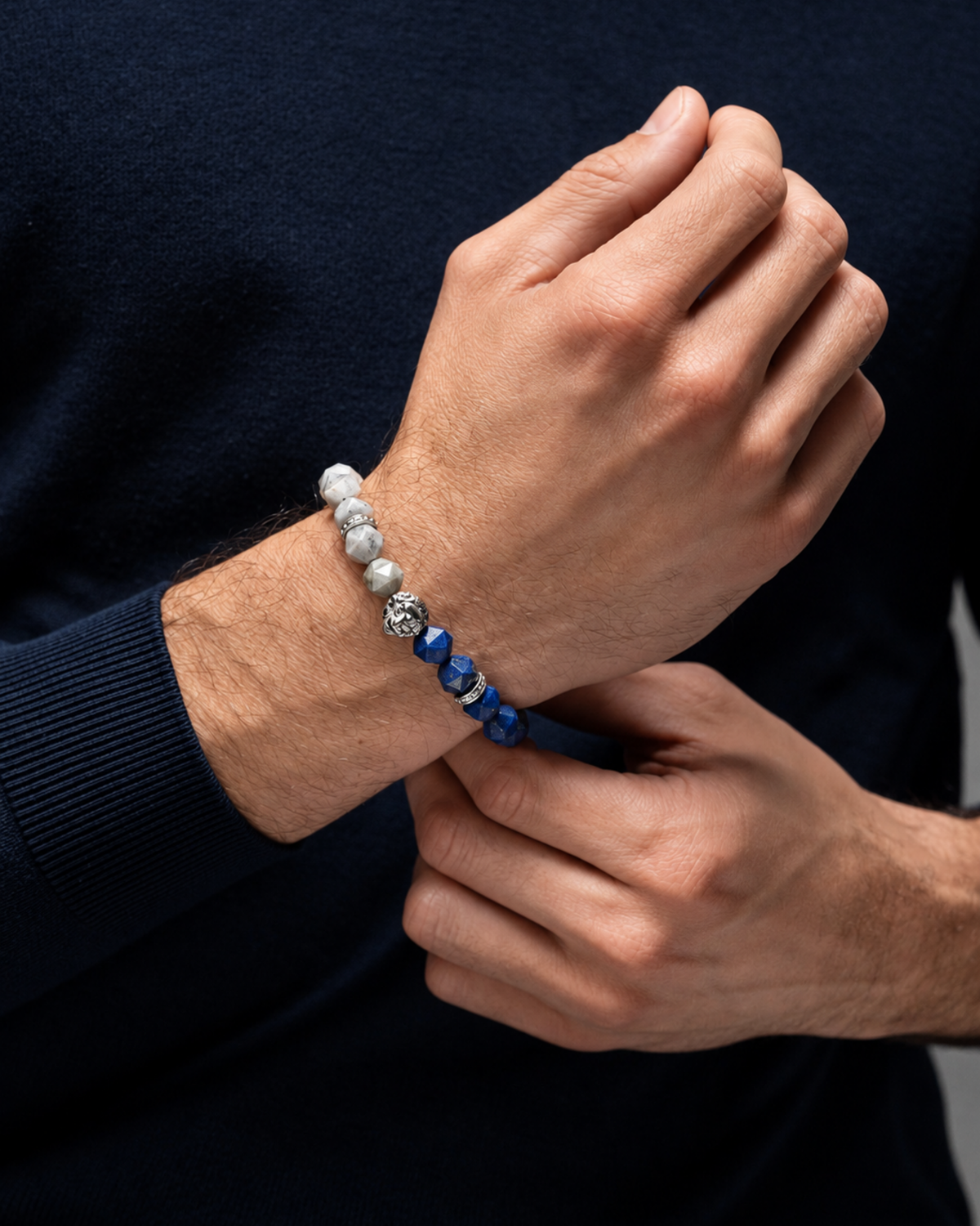 Lion bracelet close-up on wrist, blue lapis lazuli and gray labradorite beads on black cord