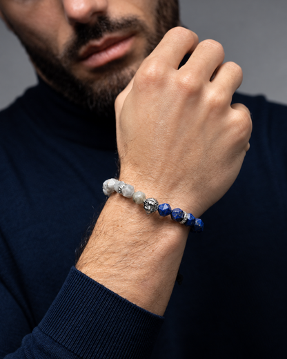Lapis lazuli and labradorite lion bracelet worn on wrist; blue and gray beads on black cord