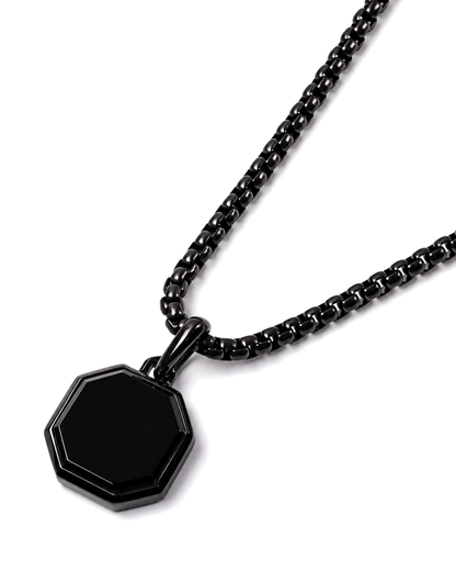Black octagonal pendant on curb chain, angled close-up