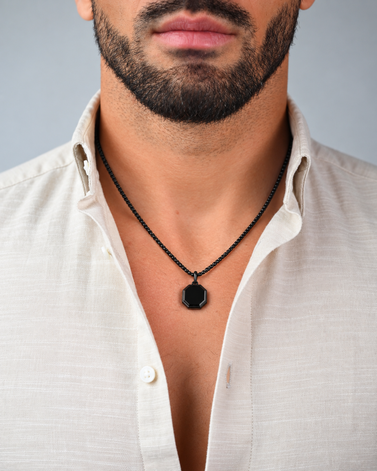 Black octagonal pendant necklace worn with white button-up shirt