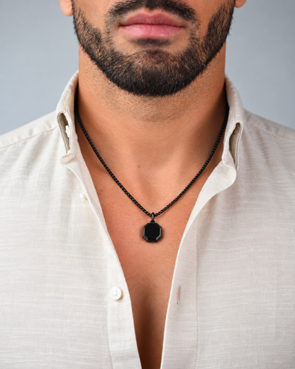 Black octagonal pendant necklace worn with white button-up shirt