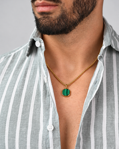 Gold chain necklace with octagonal green malachite pendant, worn at neckline