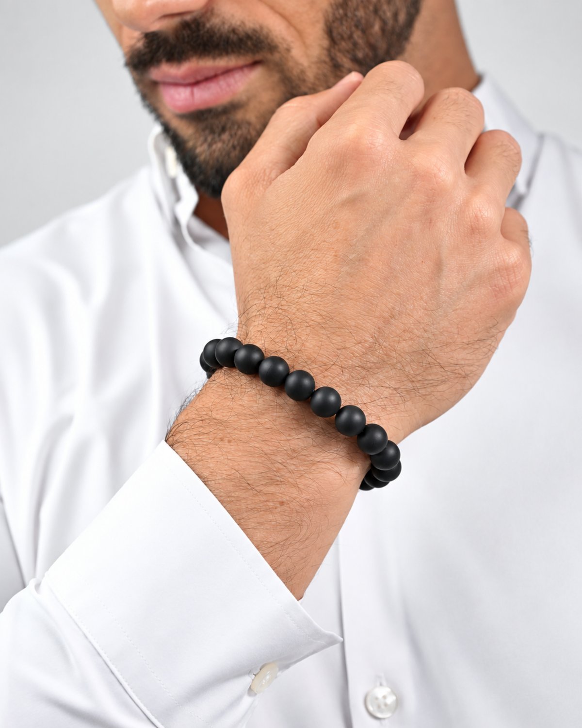 Black beaded bracelet worn on a man’s wrist