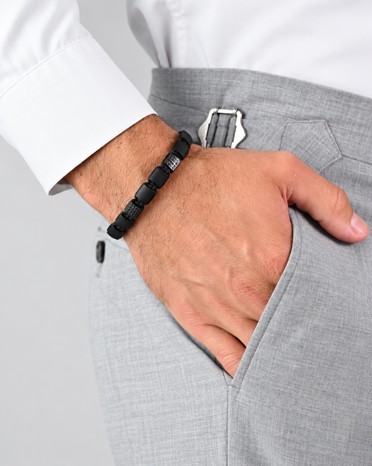 Black bead bracelet on wrist with braided cord and square black bead links