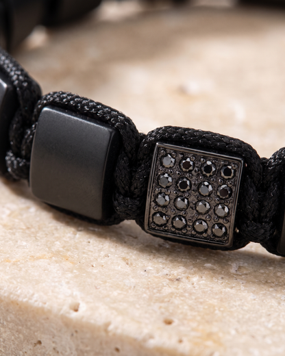 Close-up of black bead bracelet featuring a square rhinestone-like center panel