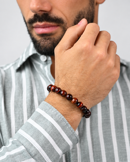 Tiger eye bead bracelet on man’s wrist with red-brown and dark round beads