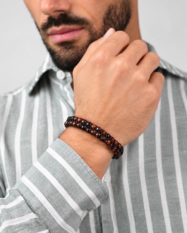 Man’s wrist wearing tiger eye double-row bead bracelet with dark red and brown beads
