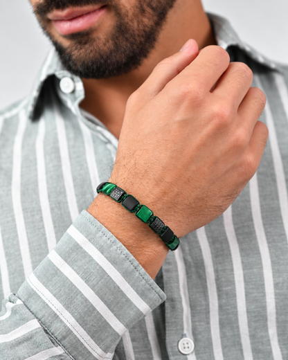 Green and black bead bracelet on wrist with square black onyx beads and green stone panels