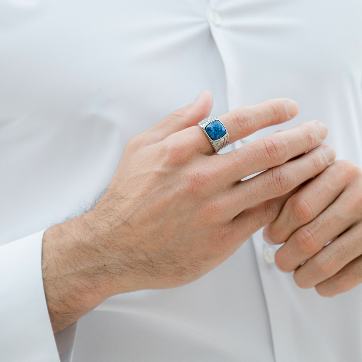 Man’s hand wearing silver 925 ring with square blue lapis stone