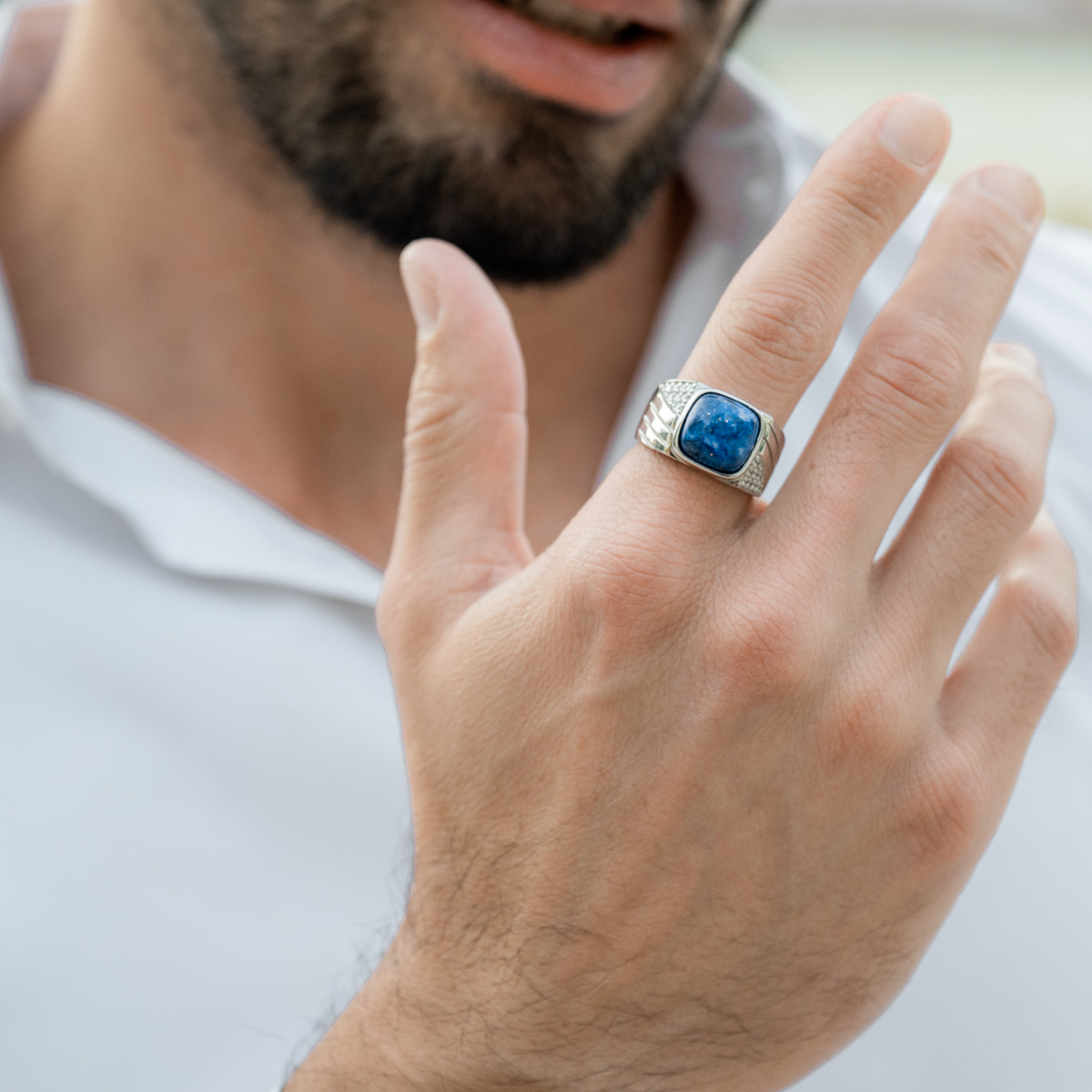 Man’s hand wearing silver 925 ring with blue lapis center stone