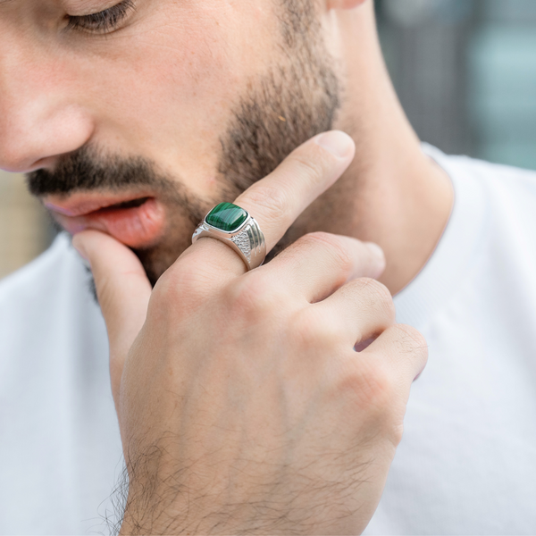 Close-up of a sterling silver ring with green malachite cabochon on a man's finger