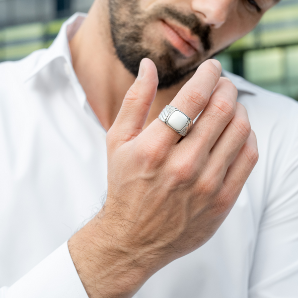 Sterling silver ring with white Howlite on man's hand, worn with a white shirt