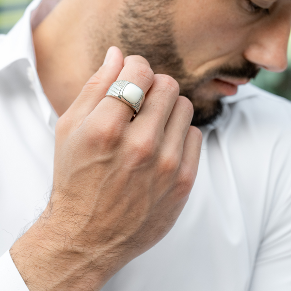 Sterling silver ring with white Howlite on man's hand, silver band with engraved lines
