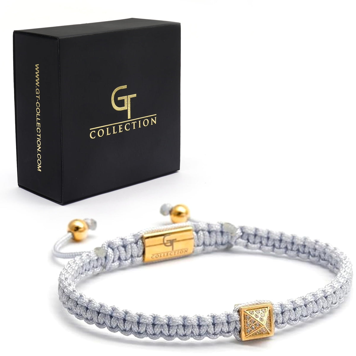 Men's pyramid bracelet with light gray cord and gold pyramid centerpiece beside black box